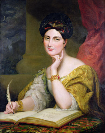 A woman in a yellow dress writing with a feather quill, seated beside an open book
