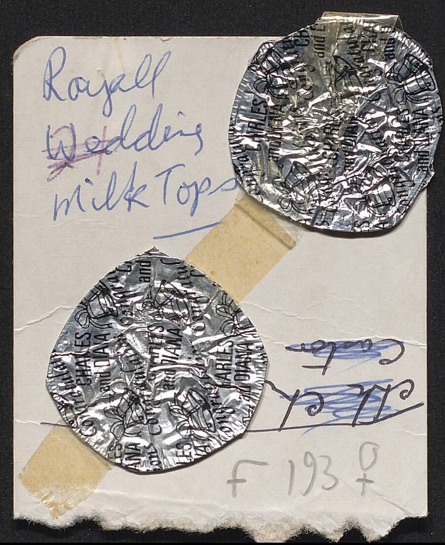 Two round, silver foil candy wrappers taped to a paper with handwritten notes