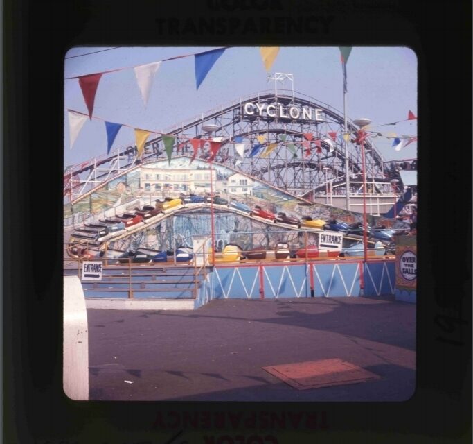 The Cyclone roller coaster with colourful flags, seen at an amusement park