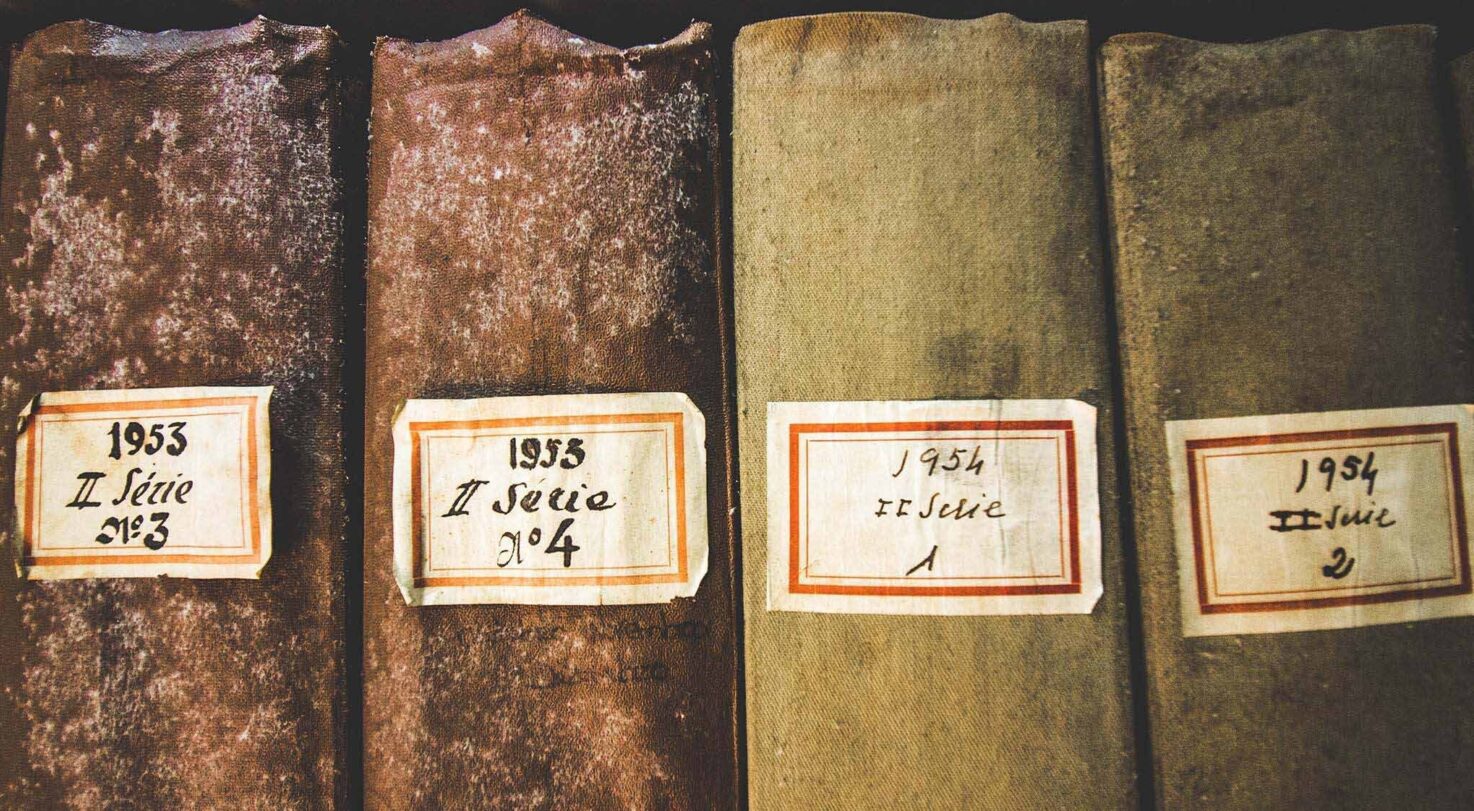 Four old books with labels showing publication years, including 1953 and 1954.