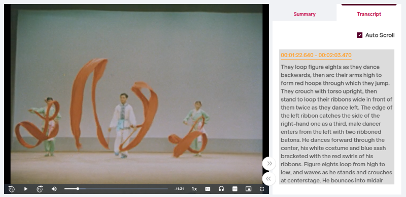 Three dancers in colorful costumes creating flowing figures with red ribbons on stage.