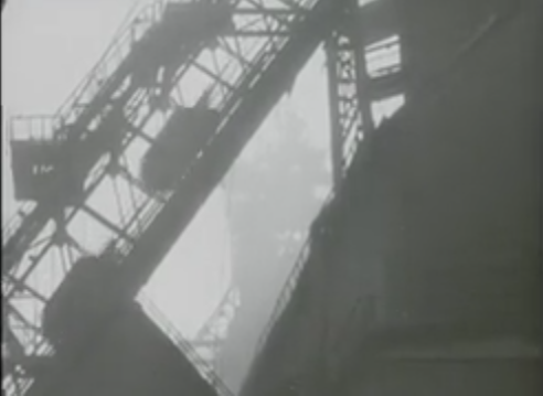 An industrial structure with a large conveyor belt in foggy weather.