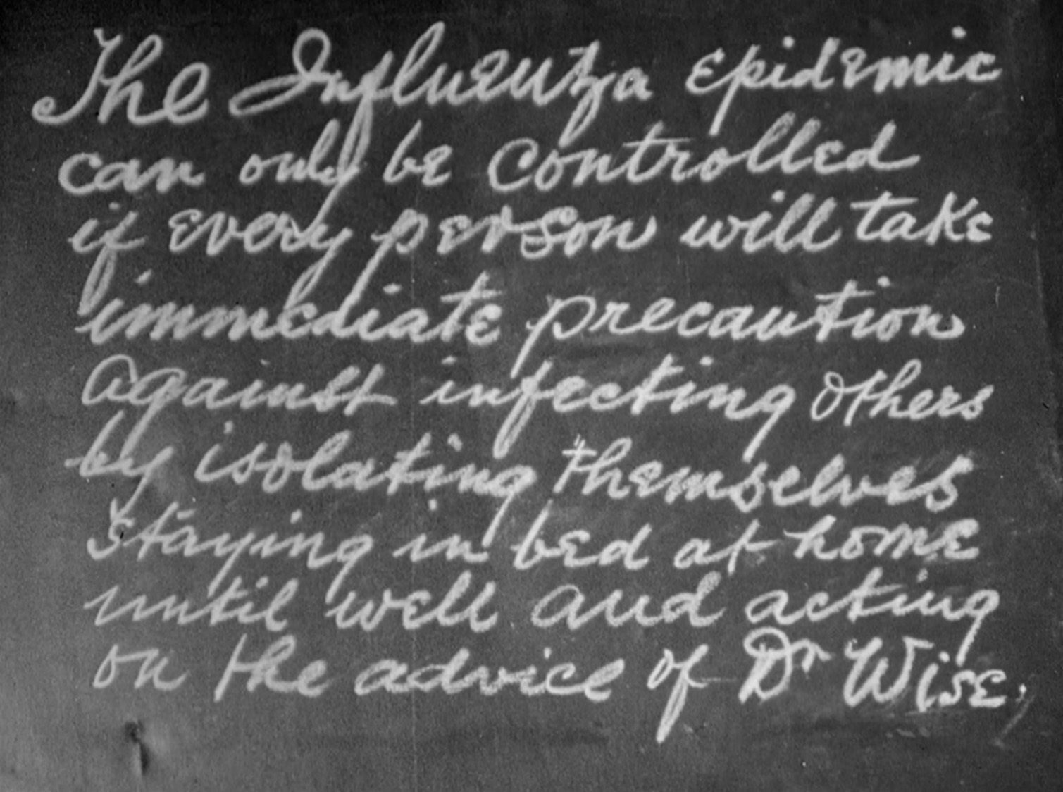 Handwritten message on a blackboard about preventing influenza by isolating and resting at home.