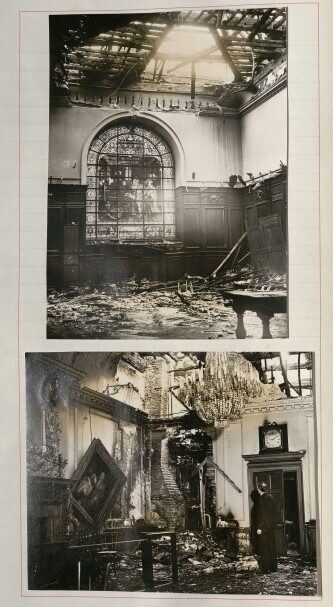 A damaged room with a broken chandelier, stained glass windows, and debris on the floor.