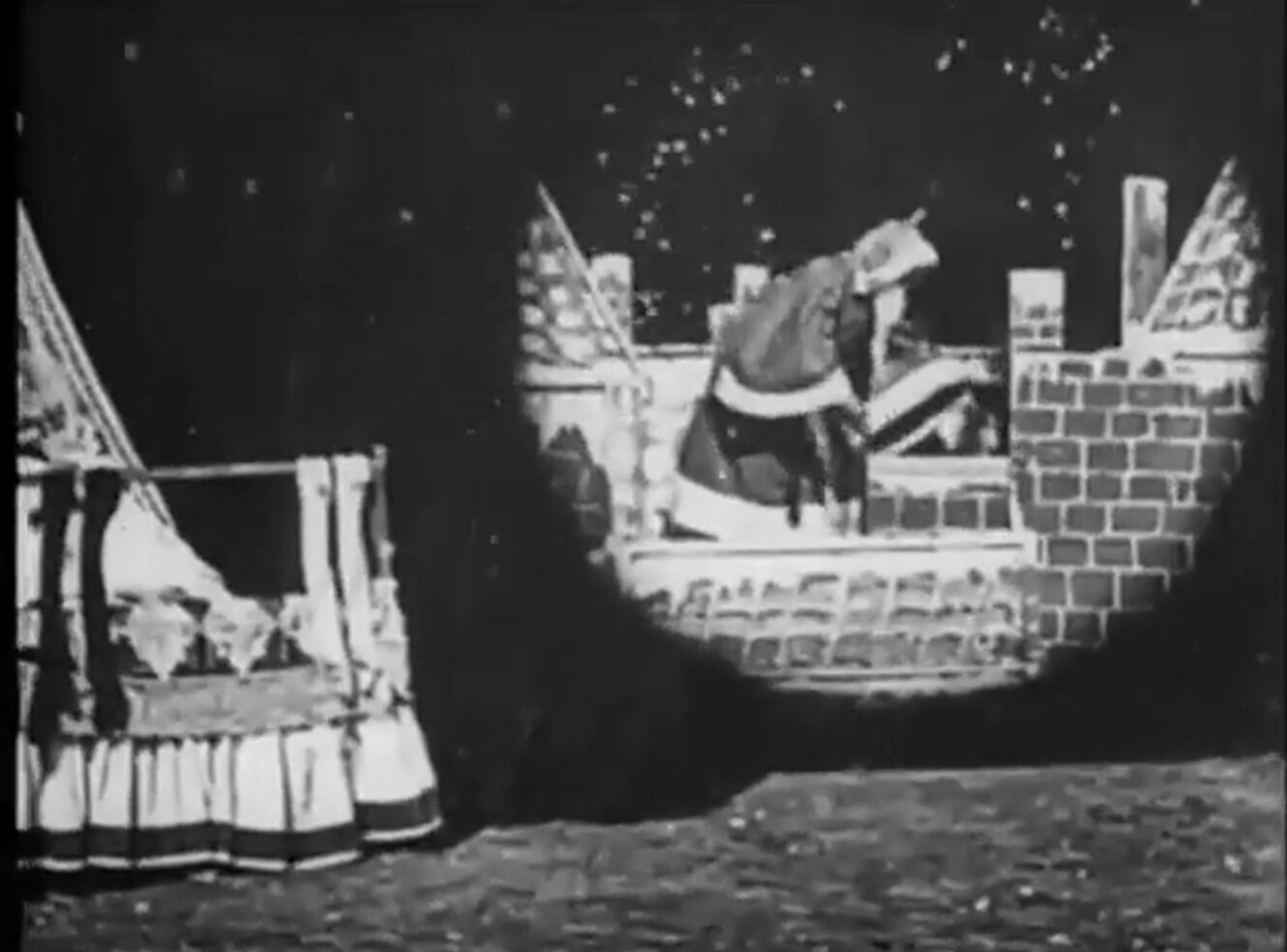 A black and white film scene showing Santa Claus entering a brick chimney with snowfall.