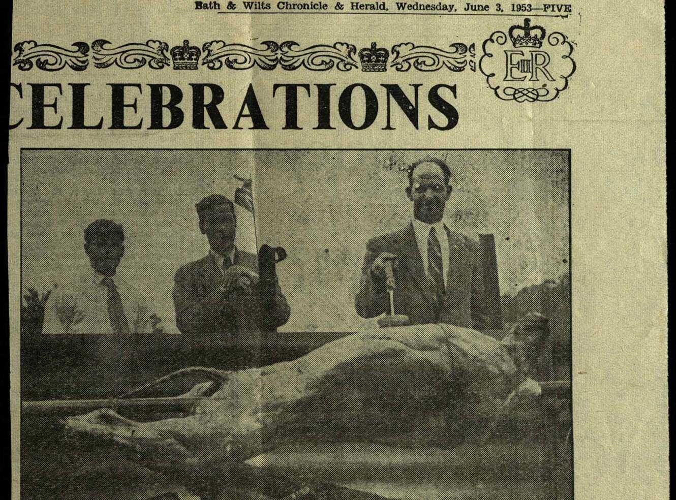 Three men in suits holding a flag and a hammer next to a suckling pig on a newspaper front page.