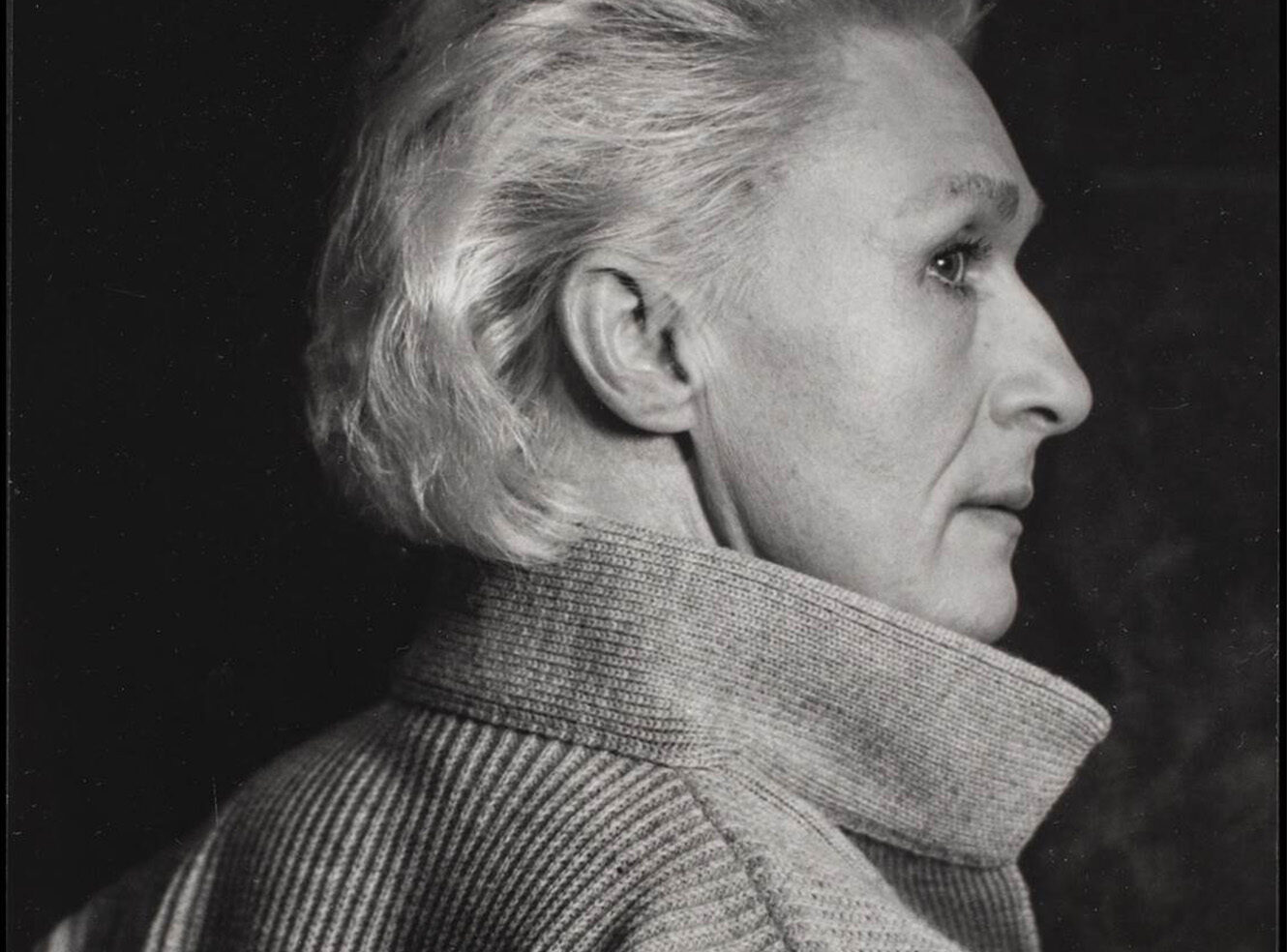 A black-and-white side potrait of a woman with short grey hair.