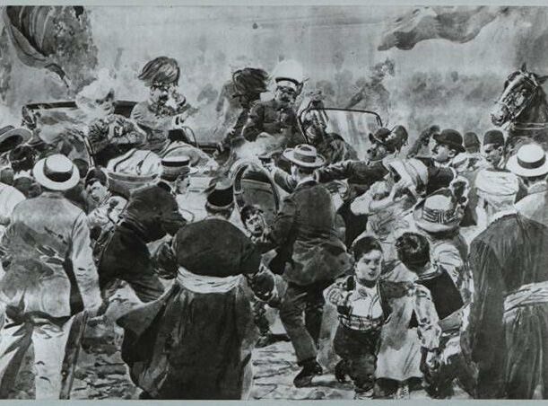 A chaotic crowd surrounds a car with a military officer, people reaching out to him.