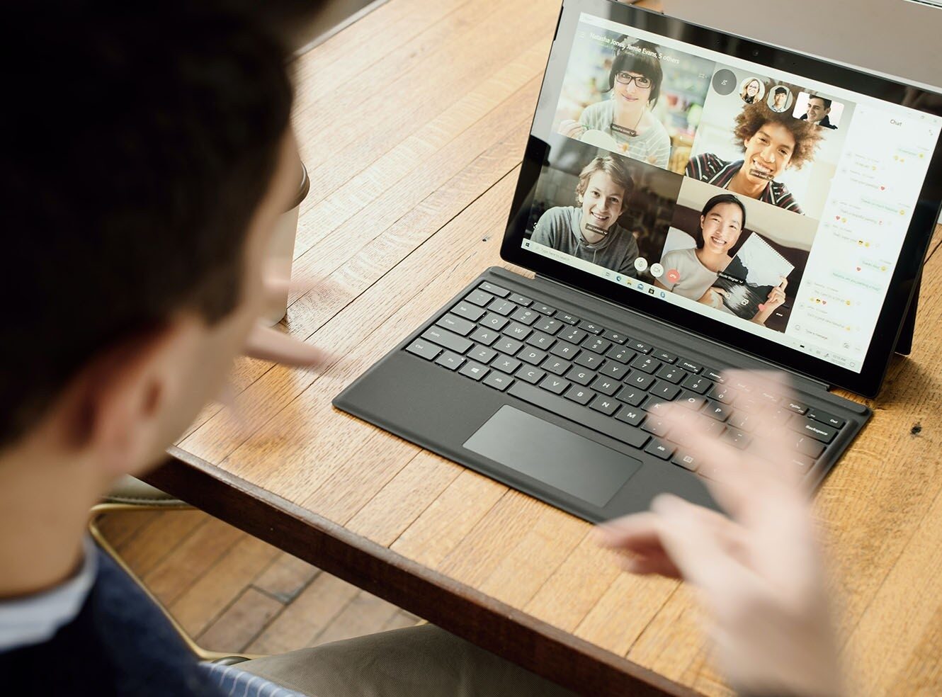 A person in front of a laptop, video chatting with five people on screen.