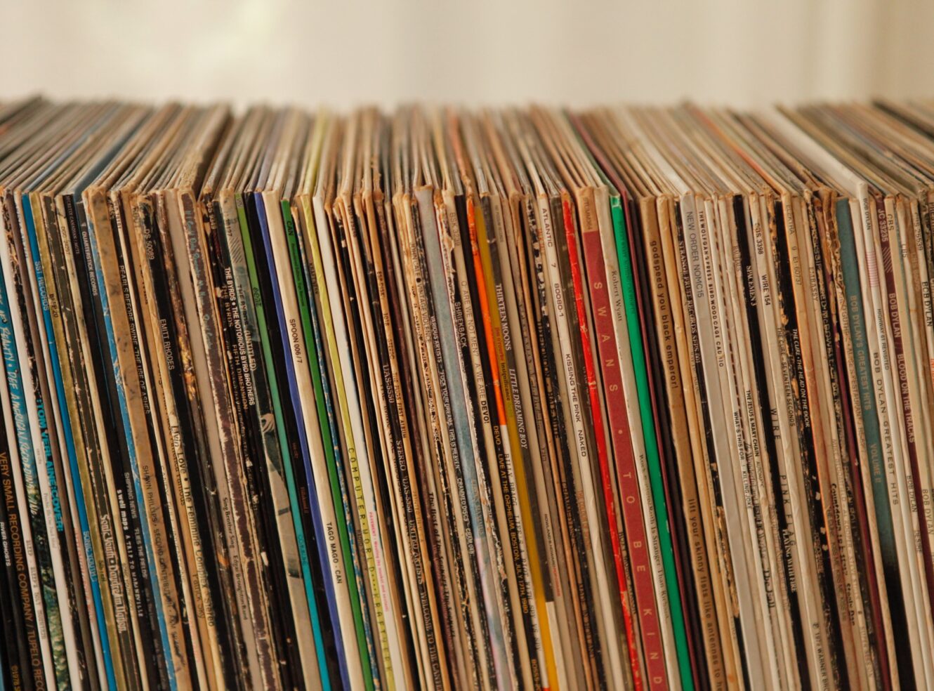 A collection of vinyls on a shelf.