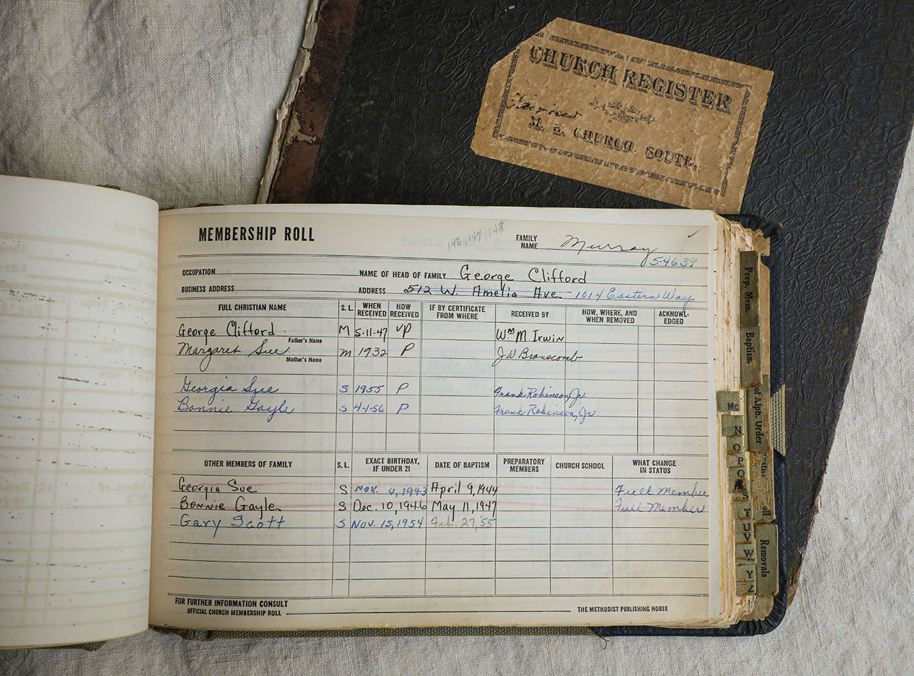 An open ledger displaying a church membership roll page with handwritten entries for names and dates.