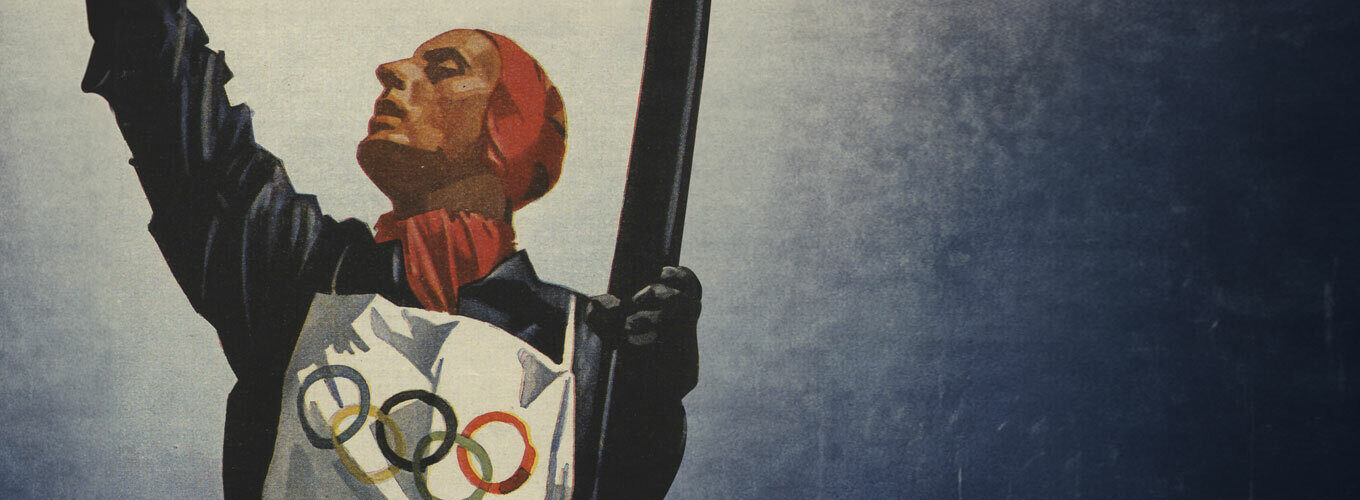 A person in a red scarf holds a flag with Olympic rings against a blue background.