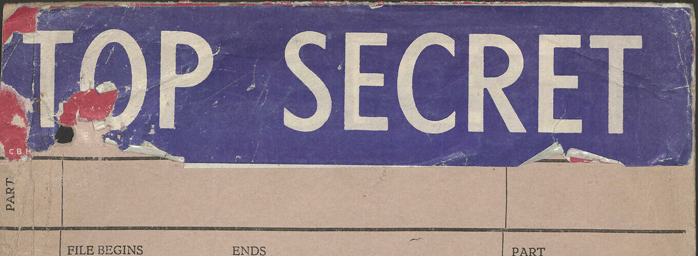 A worn document cover that reads 'TOP SECRET' in large white letters on a blue background.