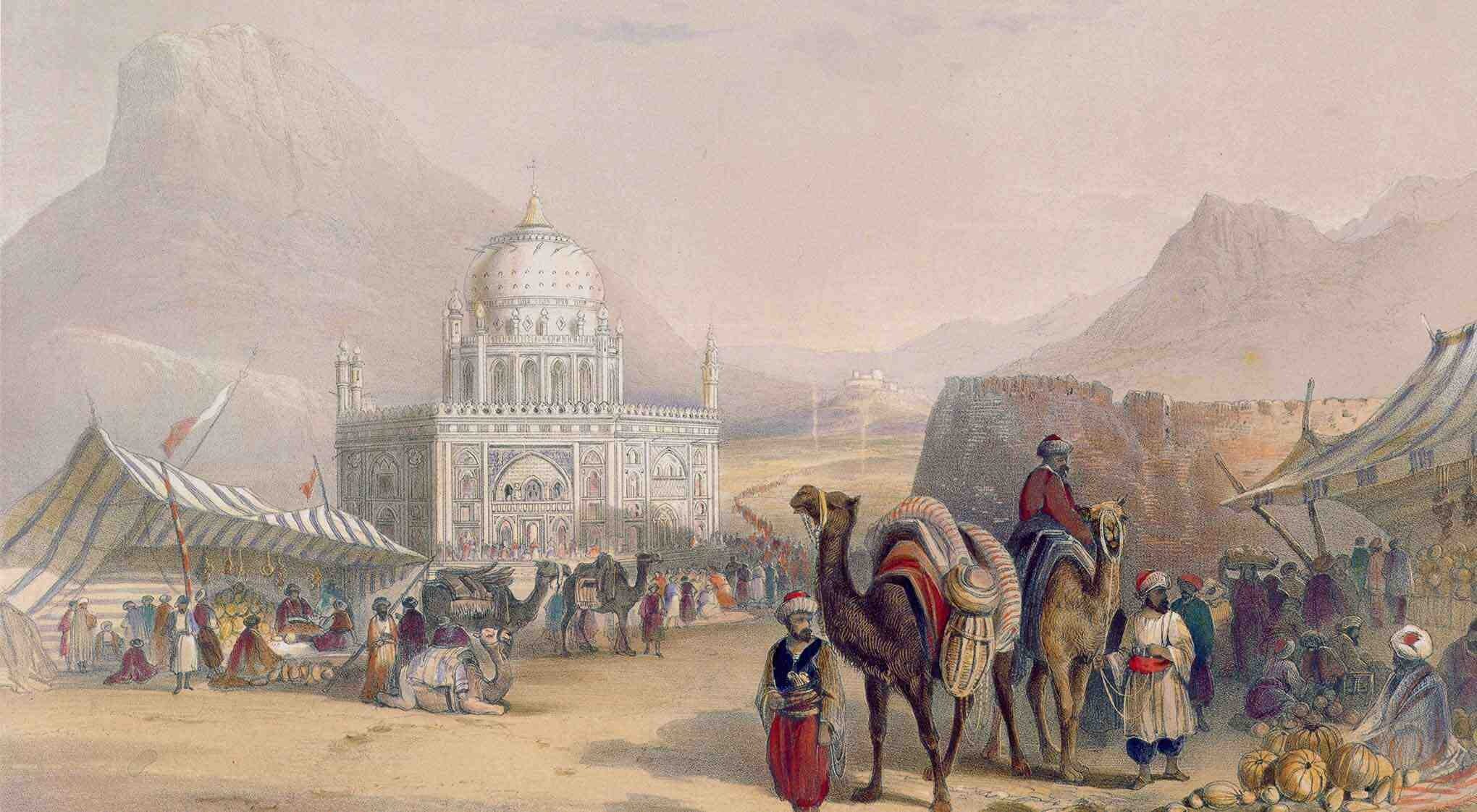A busy market scene with people, camels, and a white mosque in the background.