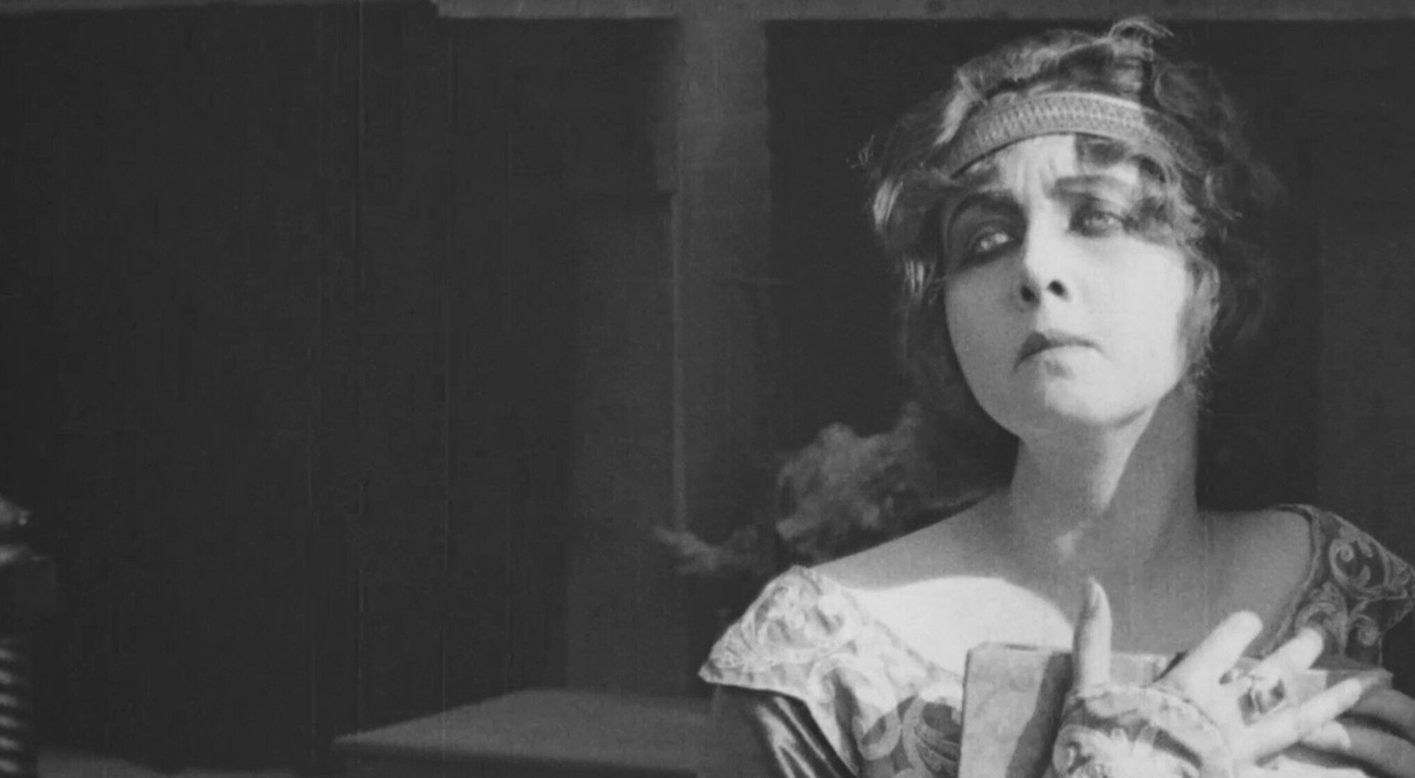 A woman in a flowing dress holding a book.